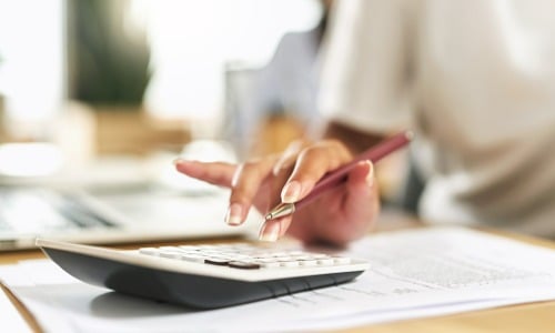 Woman using a calculator to budget her finances