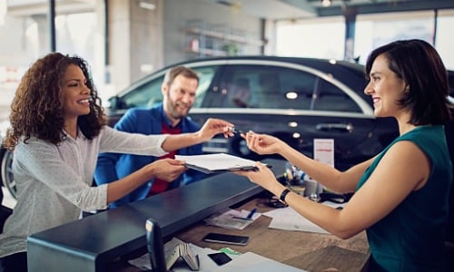 Couple buying new car and signing contract