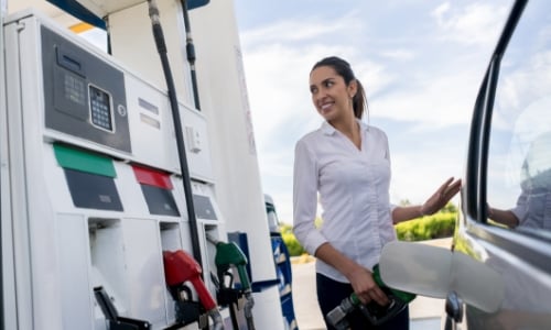 Woman pumping gas into her car