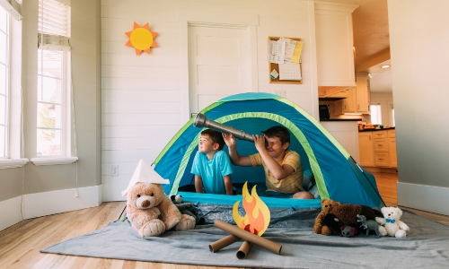 Kids pretending they are camping inside their house