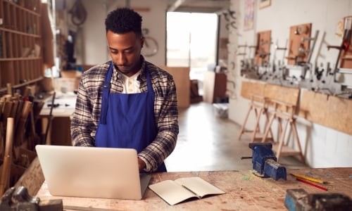 Small business owner typing on his laptop