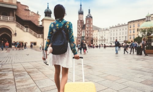 A woman carrying a suitcase for travel