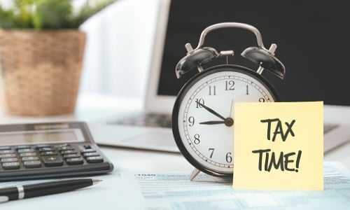 Ticking clock with “tax time” sticky note