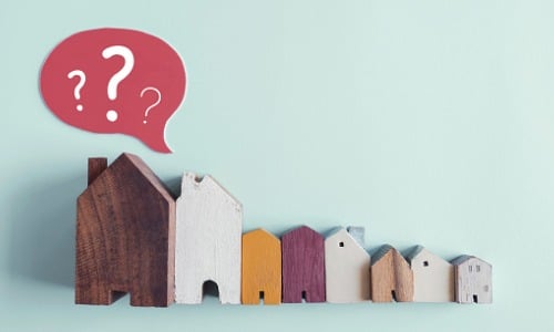 Wooden houses with question marks