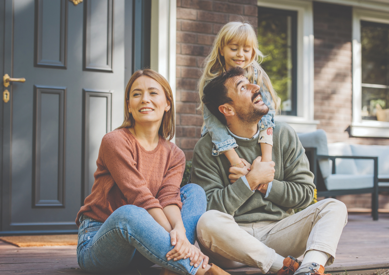 Family sitting on the front porch of their home