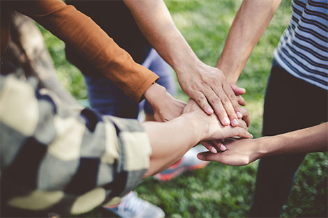 group of hands forming a circle