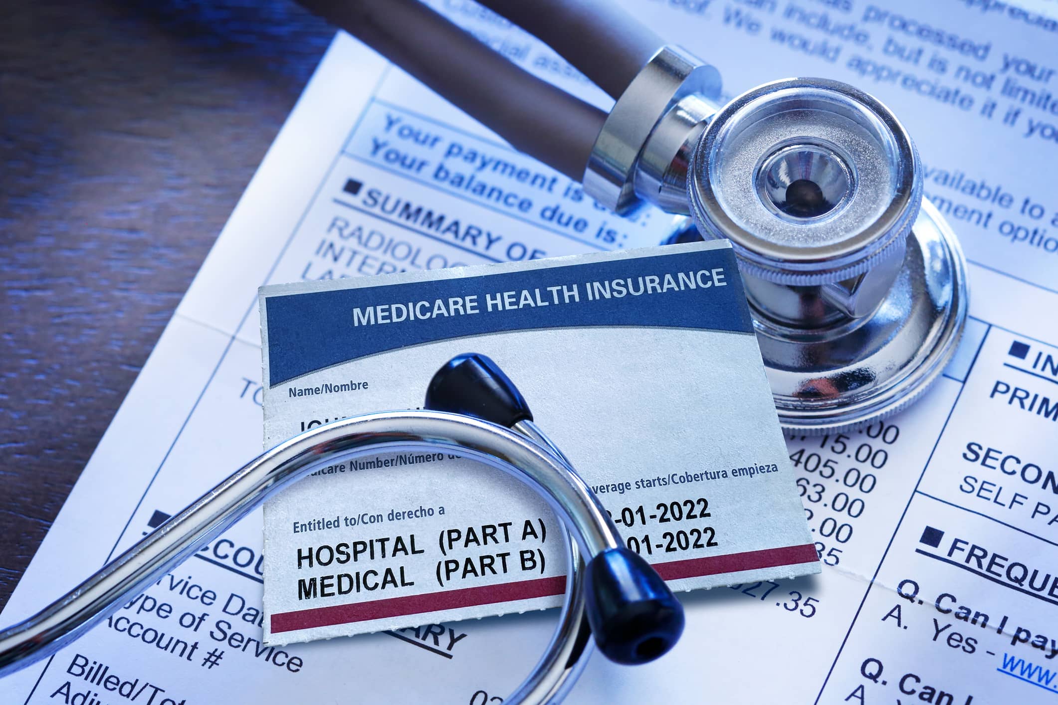 Medicare insurance card and a stethoscope on a medical bill