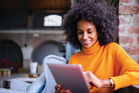 a smiling woman using a tablet