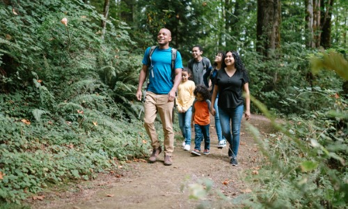 Happy family walks trail in the woods