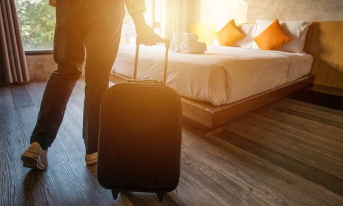 Person with a suitcase going into a hotel room