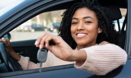 Woman holding keys to her new car