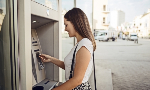 Woman putting her card into an ATM