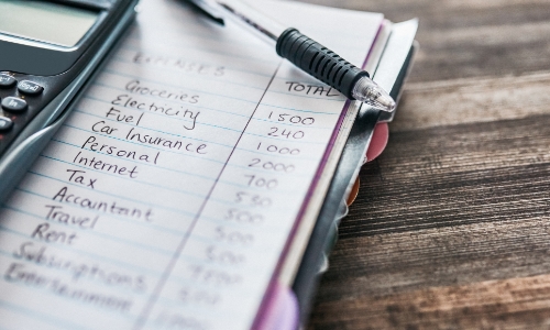 Monthly finances list written on paper